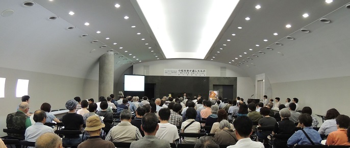 イベント参加者が椅子に座って傾聴している様子を背後から撮影した写真